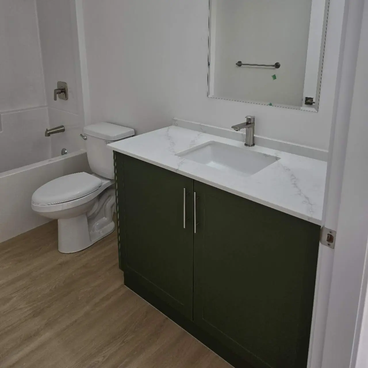 Modern residential bathroom vanity unit with white countertop and green cabinet base
