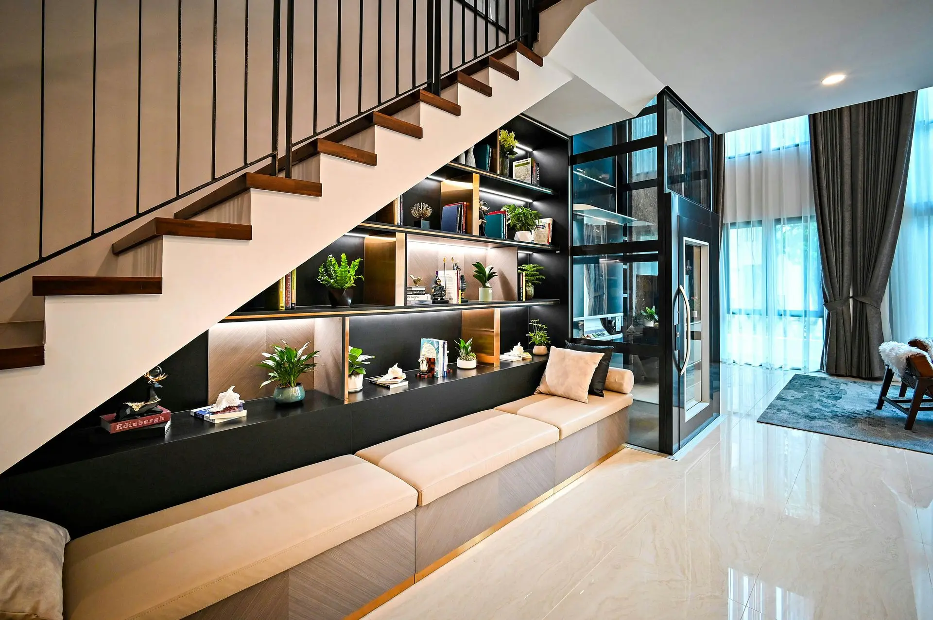 Custom built-in joinery with integrated shelving, wall paneling and under-stair cabinetry in a modern residential interior