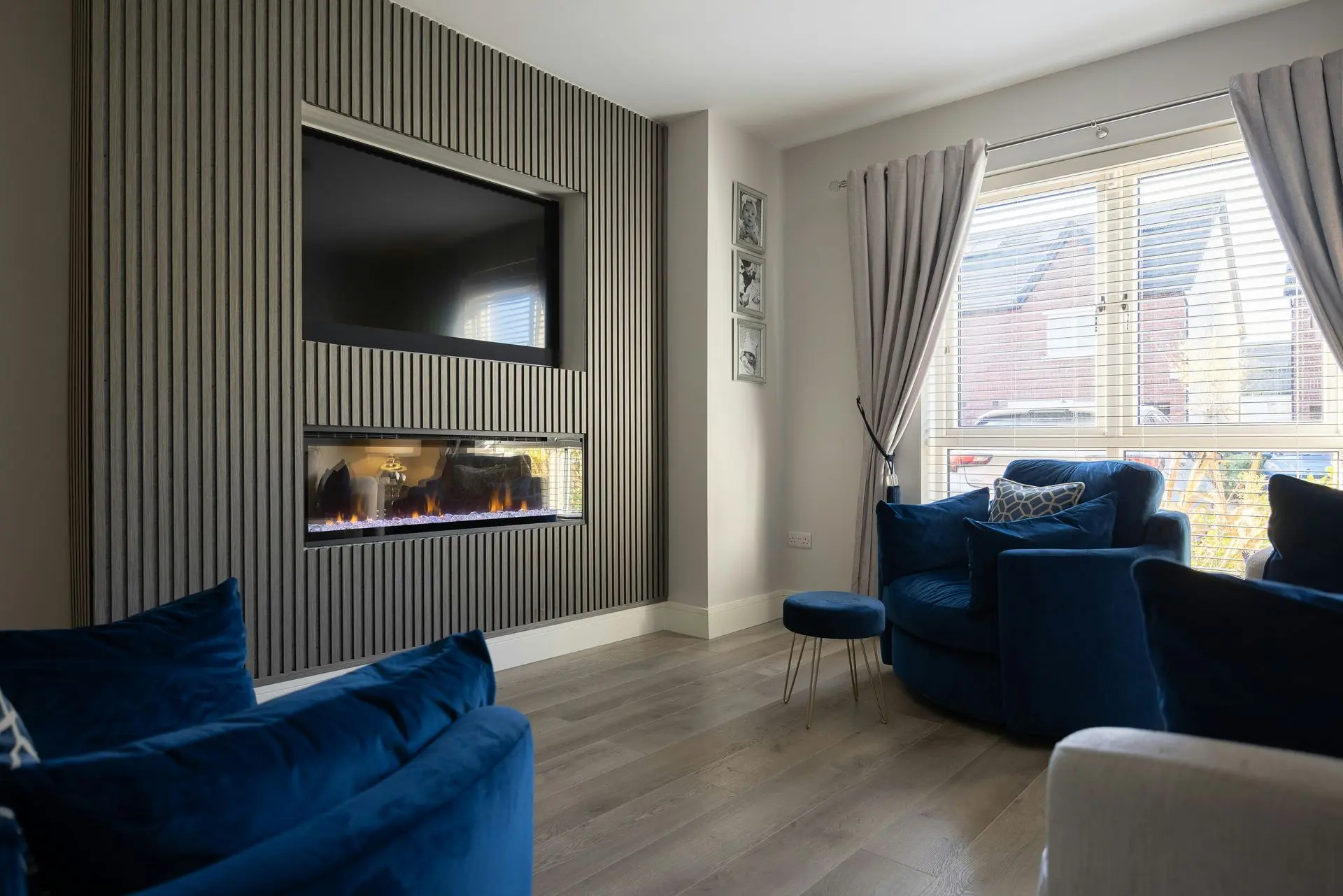 Modern feature wall with vertical wood panels, integrated fireplace and built-in TV in residential interior