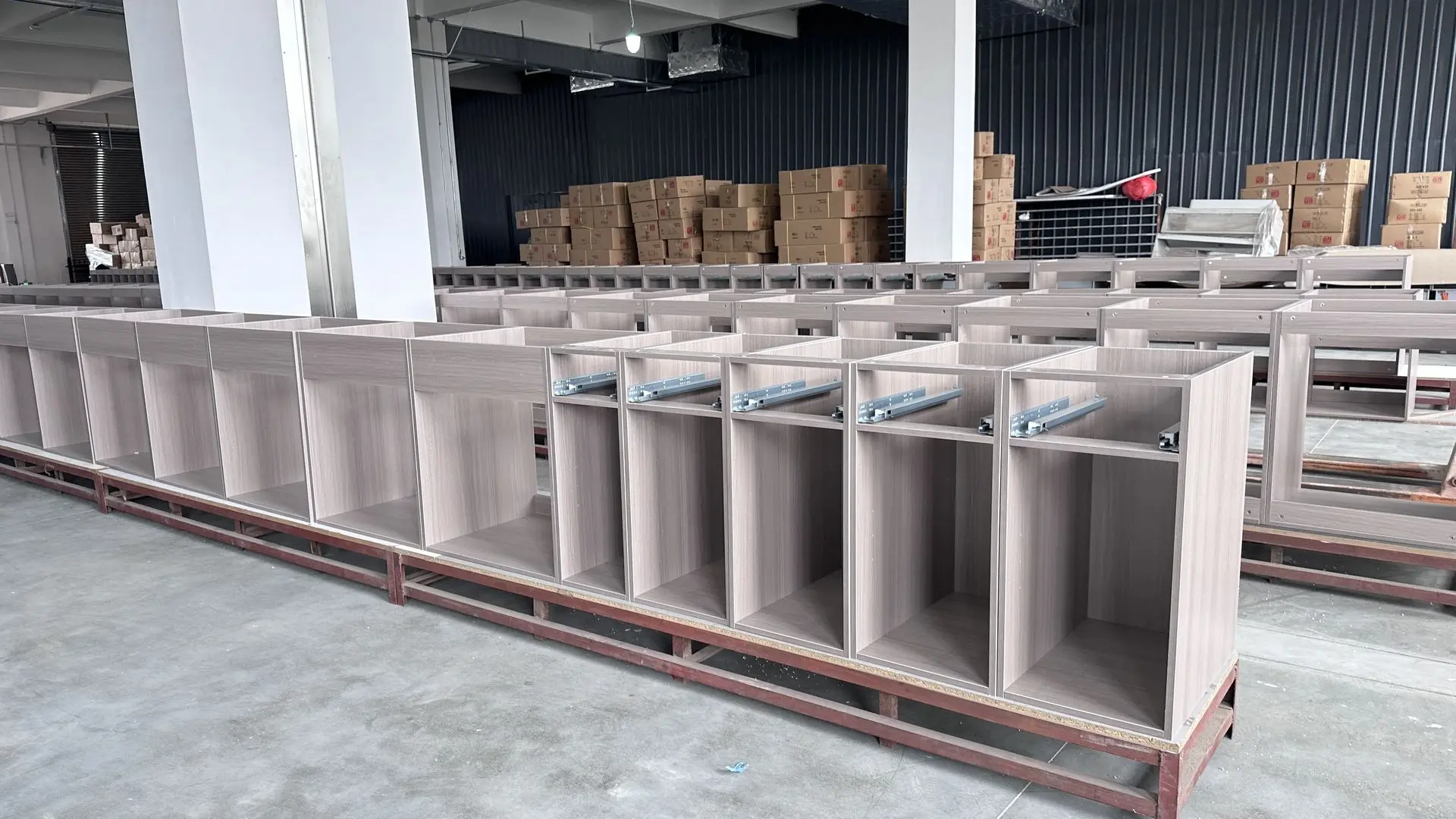 Modular cabinet units in factory production showing standardized furniture components for large-scale projects