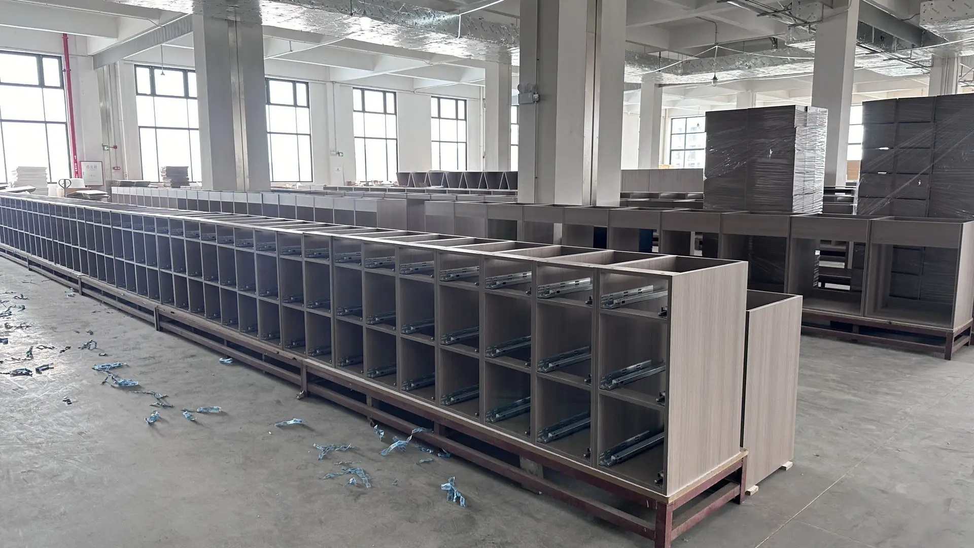 Large-scale millwork cabinet production showing uniform units with precision drawer hardware installation