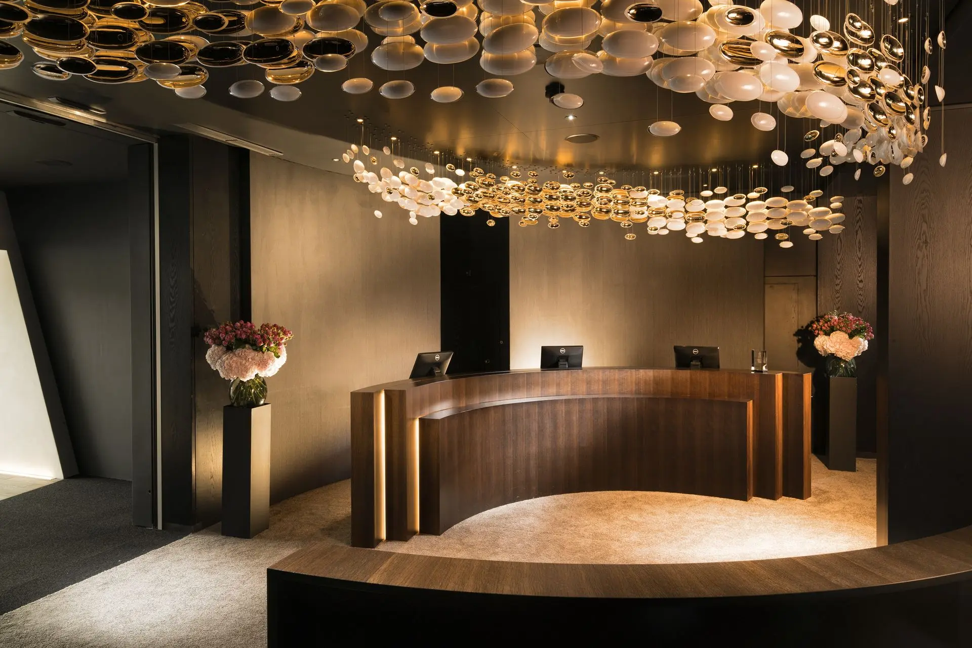 Hotel reception desk architectural millwork with curved wood counter and feature lighting