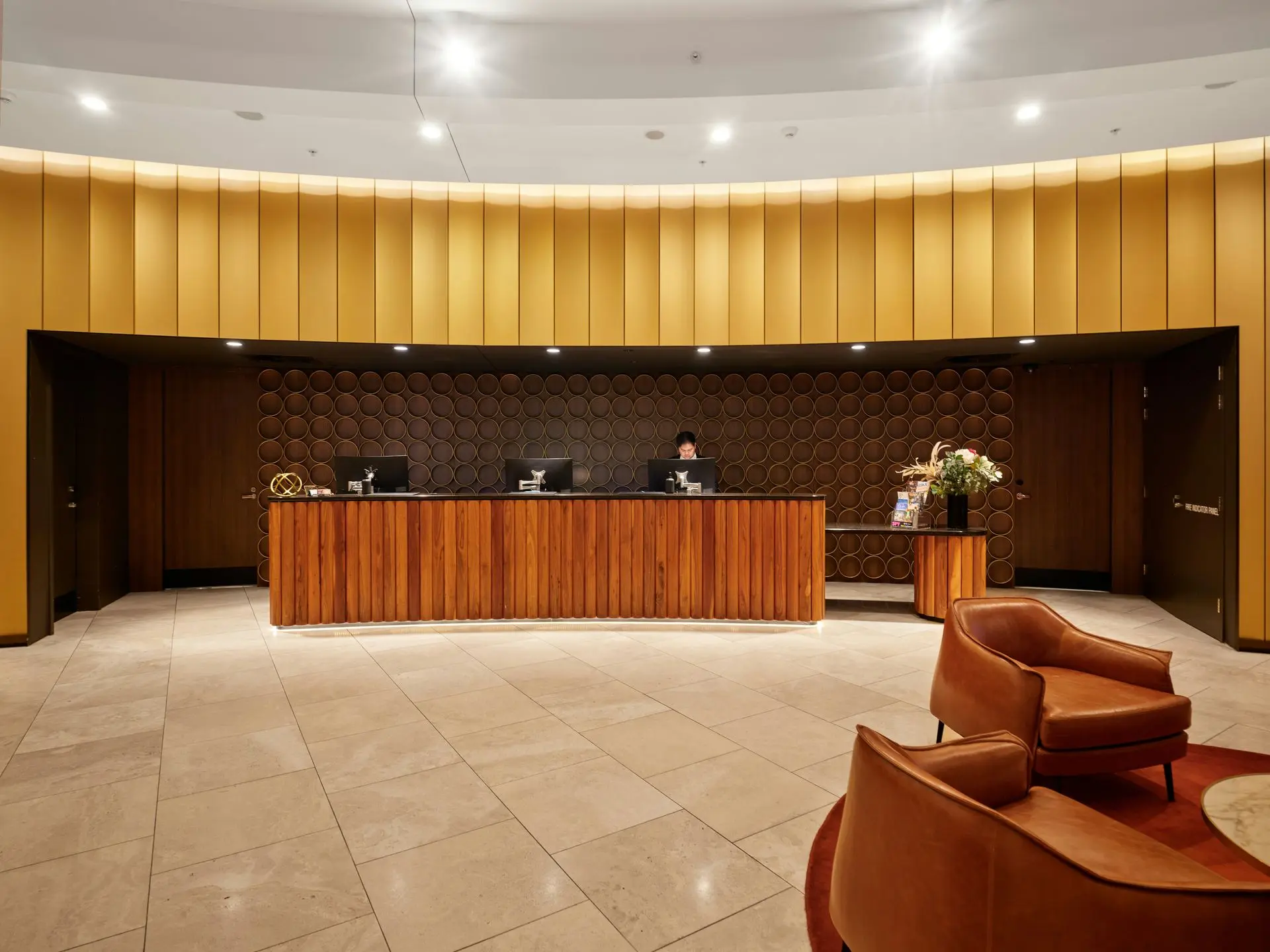 Wood Reception Desk with Textured Finishes in Modern Lobby Design Custom wooden reception desk with textured wall panels and warm lighting showcasing premium materials in a modern hotel lobby