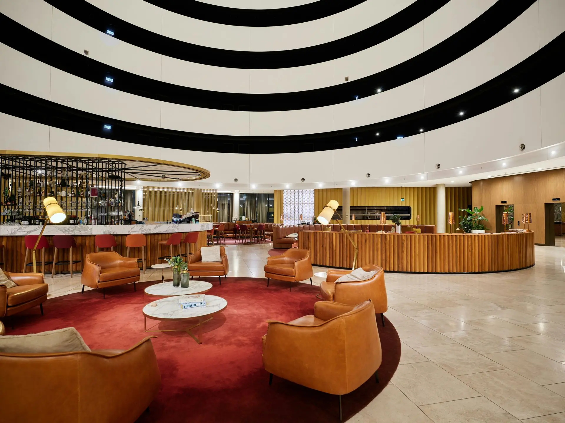 Hospitality Millwork in Hotel Lobby Design Hospitality millwork in hotel lobby with curved wood paneling and circular bar design