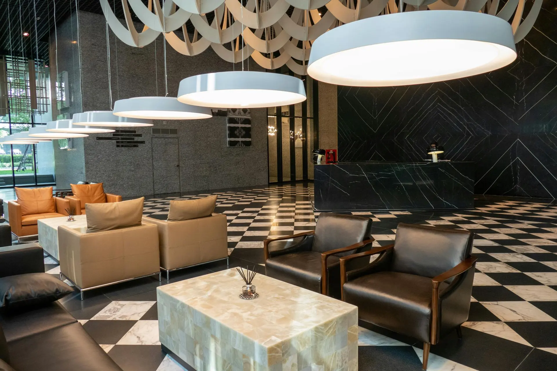 Mixed Material Hospitality Millwork Design Hospitality millwork with stone reception desk and mixed material finishes in hotel lobby