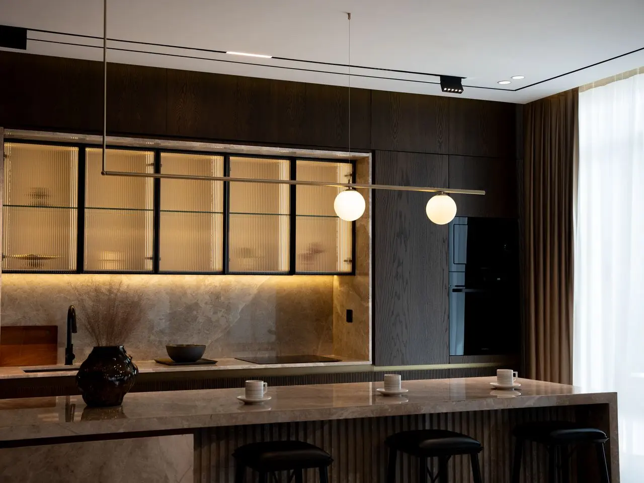 Luxury custom kitchen featuring integrated LED millwork lighting and illuminated glass display cabinets
