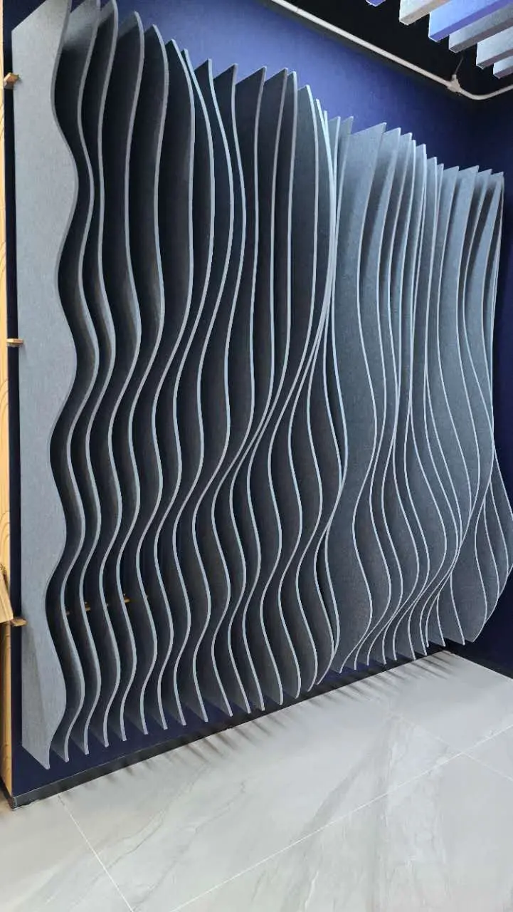 Modern Wave PET Felt Acoustic Wall Panels Wave-shaped PET felt acoustic wall panels installed as a decorative sound-absorbing feature in a modern commercial interior.