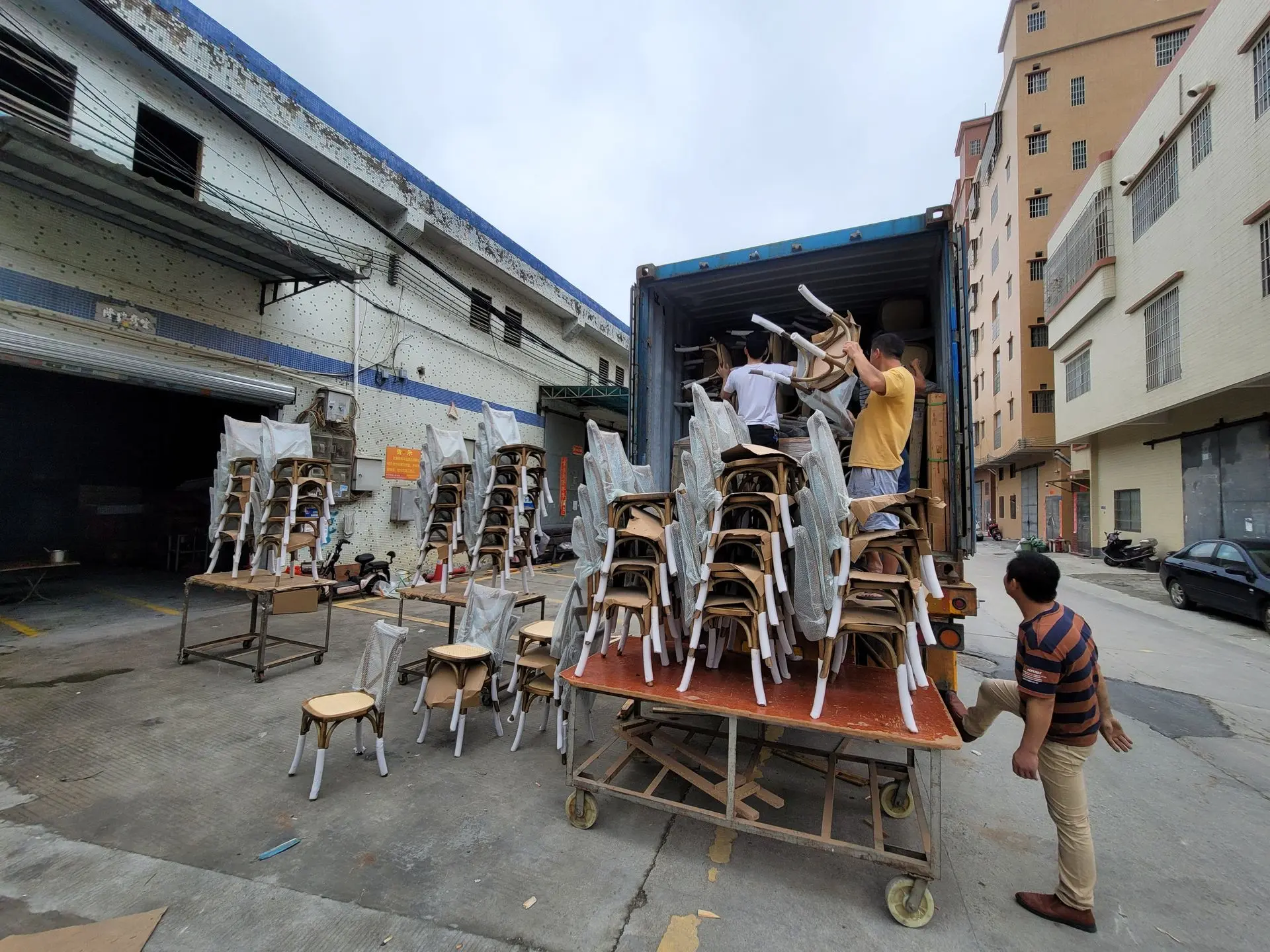 Furniture Export Packaging for Secure Container Loading and Shipping Furniture export packaging with wrapped chairs being loaded into a shipping container for safe international delivery