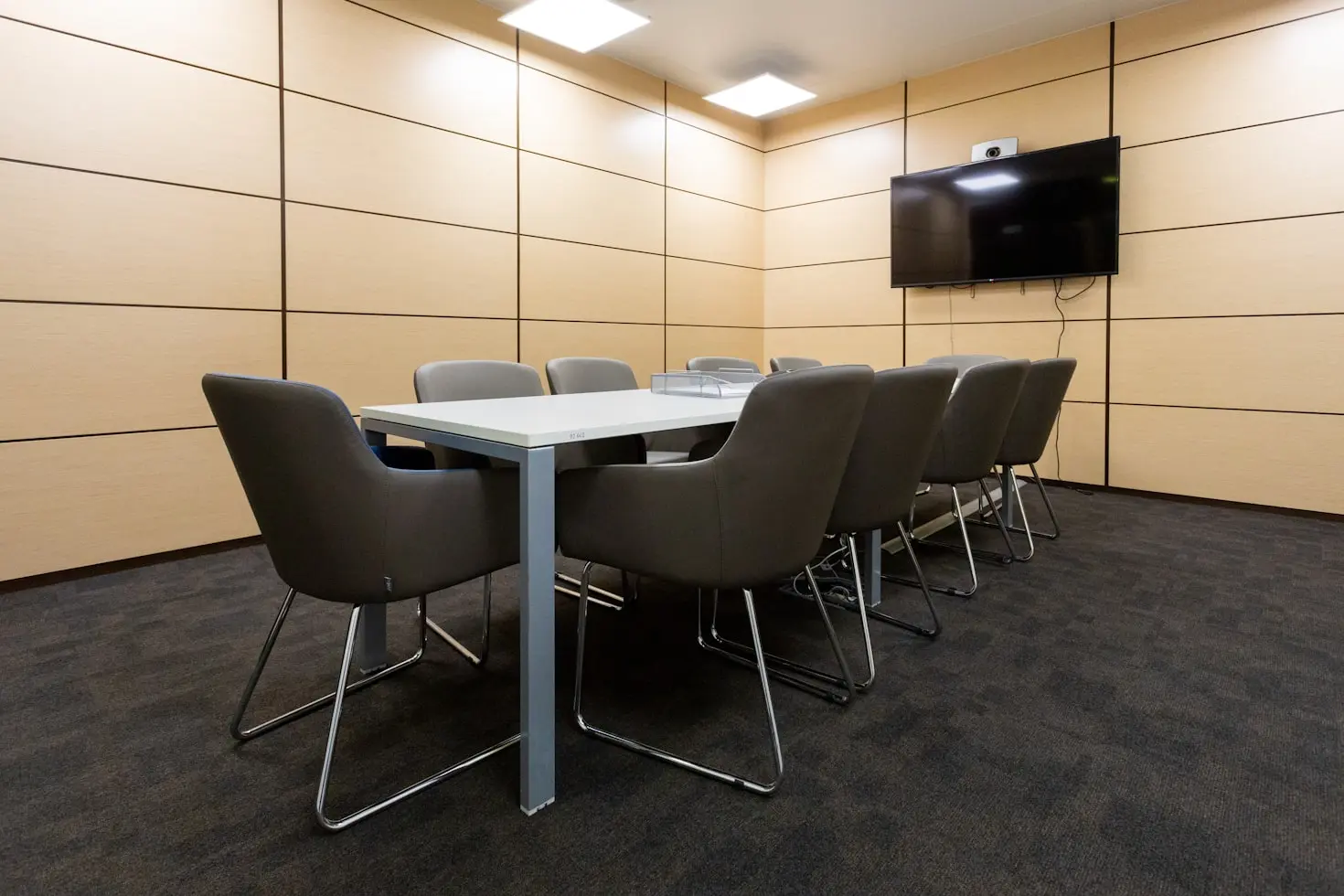 Meeting room with integrated display, camera, and wood wall millwork