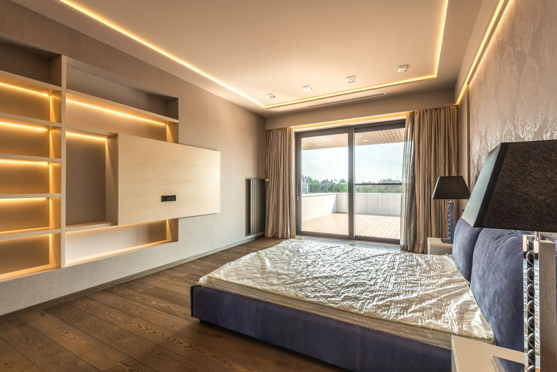 Custom hotel millwork wall with integrated shelving, lighting, and TV unit
