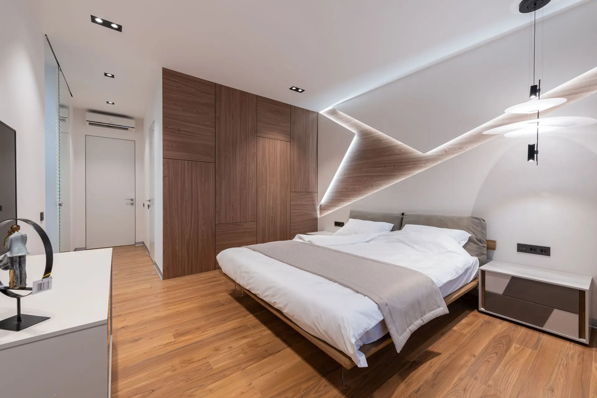 Custom hotel wardrobe with built-in storage and wood finish in a modern bedroom